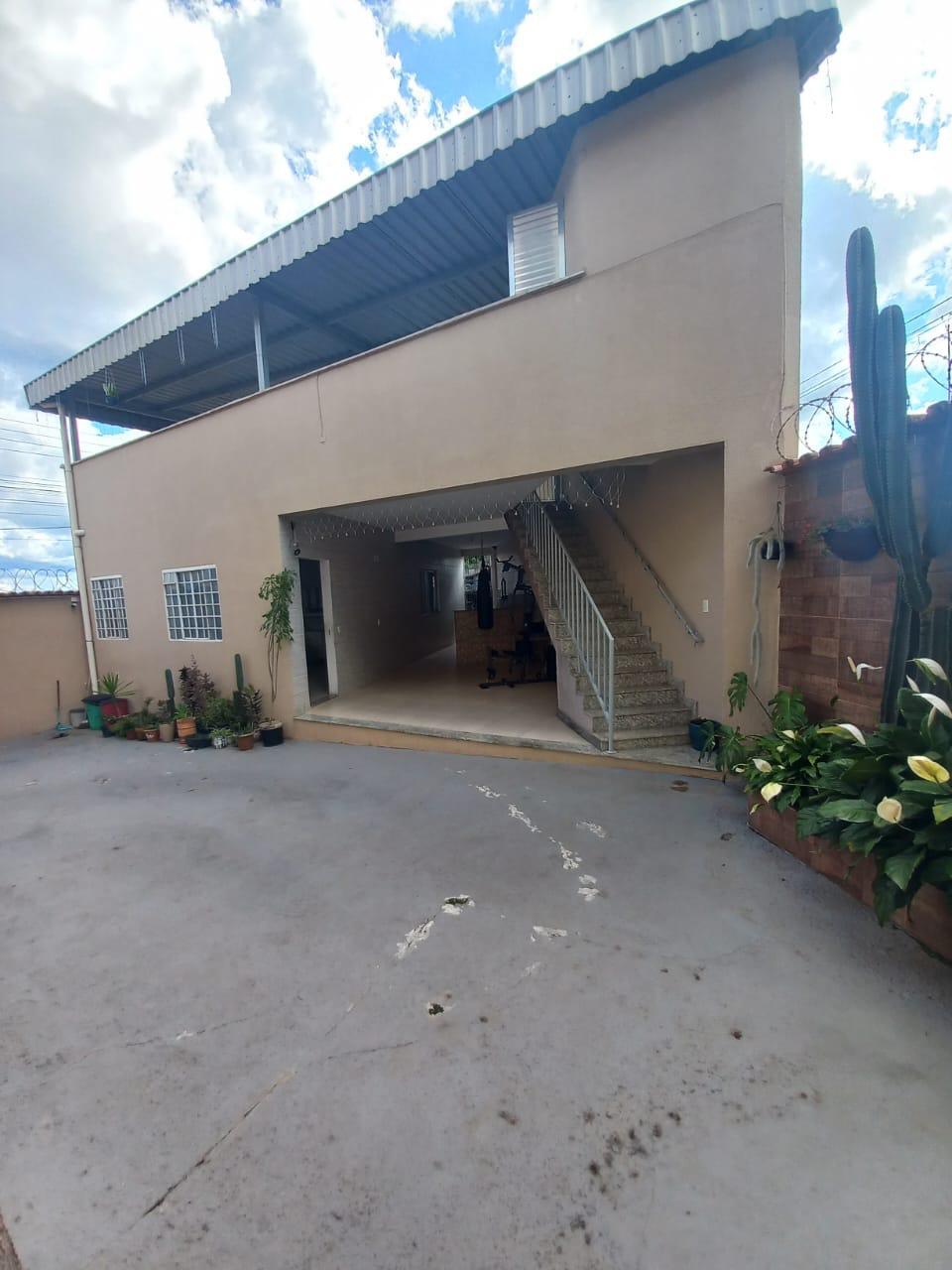Área externa da casa, com pátio amplo, espaço coberto e escada de acesso